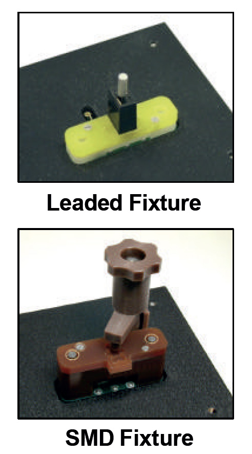 Leaded fixture: yellow plastic clamp with a metal pin on a dark base, used for through-hole testing/installation.